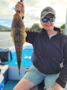 Kim with a nice Flathead caught in one of the deep holes in the Tweed River on Brad Smith Fishing Charters