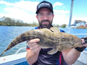 Russ with a nice Flathead ready for release on a charter with Brad Smith fishing Charters on the Tweed